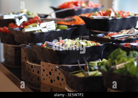 Salad bar with various vegetables and toppings on display Stock Photo