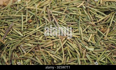 Dried rosemary leaves placed on a wooden surface Stock Photo