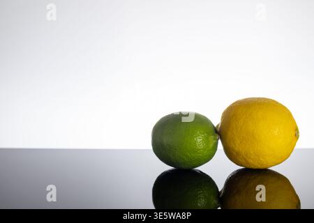 Fresh Lemon and Lime on Black Reflective Surface with White Background Stock Photo