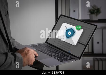 Laptop computer displaying a secure blue email notification icon on screen for digital marketing, highlighting professional business communication tec Stock Photo