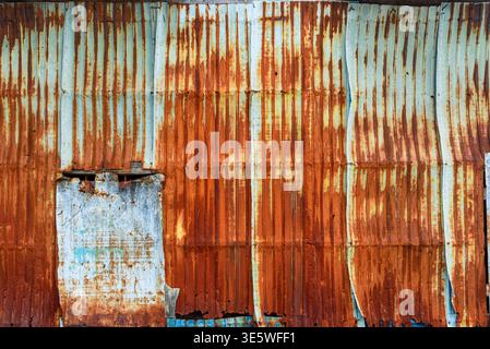 Old galvanized wall with rust on it. Corrugated zinc siding vintage texture background. Rusty metal sheet texture. Stock Photo