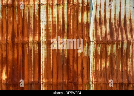 Old galvanized wall with rust on it. Corrugated zinc siding vintage texture background. Rusty metal sheet texture. Stock Photo