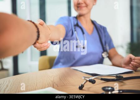 Medical, collaboration or people in clinic with handshake, greeting or cooperation for treatment plan. Meeting, deal or doctors with shaking hands Stock Photo