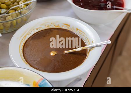 Chocolate spread or sauce in bowl with spoon on buffet table breakfast catering concept Stock Photo