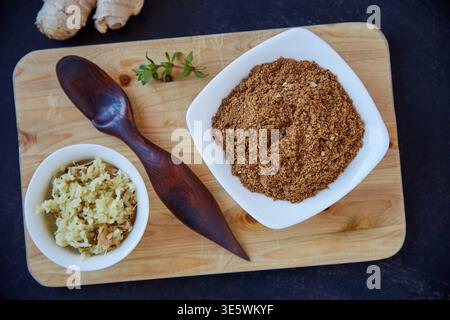 Above, ginger and spice on wooden board with spoon, powder and antioxidants for gut health benefits. Garam masala, chopped vegetable and seasoning Stock Photo