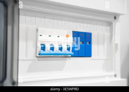 Electrical breaker switch in consumer cabinet installed on the wall of the room. Electric distribution fuse board consumer unit. Stock Photo