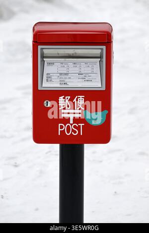 Red post box in the snow,Hokkaido island,Japan. Stock Photo