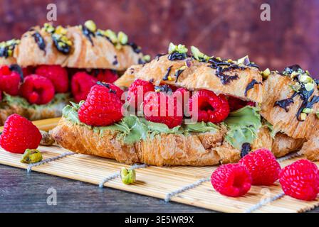 Croissants with pistachio cream, fresh raspberries and crushed pistachio nuts Stock Photo