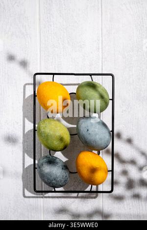 Easter eggs drying on a cooling rack after being naturally dyed with hibiscus and turmeric, creating a beautiful display of yellow and green hues, rea Stock Photo