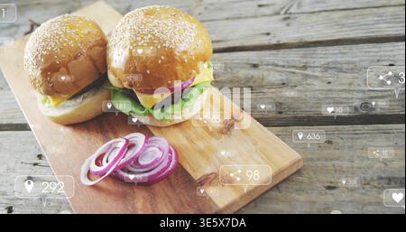 Displaying two sesame buns sitting on wooden board at table, with onion rings and social icons Stock Photo