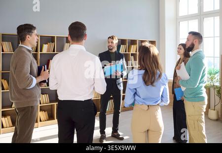 Business team standing in circle for office meeting and active discussion Stock Photo