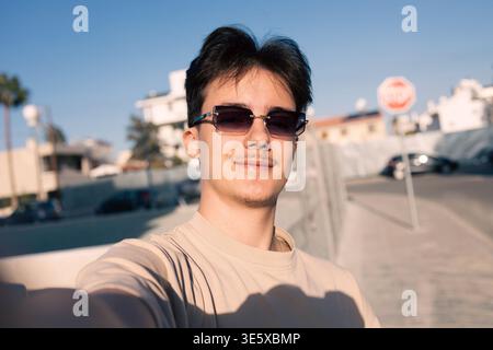 Confident young man taking selfie wearing sunglasses Stock Photo