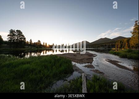 Sunrise reflecting on mountain lake surface in the Rockies Stock Photo
