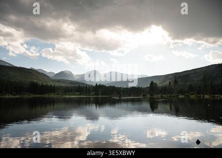 Sun rays breaking through clouds over a high altitude mountain lake Stock Photo