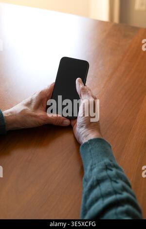 Closeup of elderly man holding blank phone in his hands Stock Photo