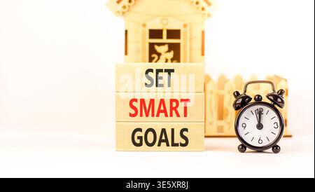 Set smart goals words symbol. Concept words Set smart goals on beautiful wooden blocks. Beautiful white background. Black alarm clock. Business and se Stock Photo