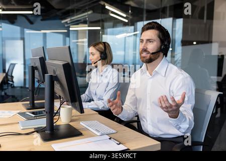 Customer service representatives working in a modern office environment, wearing headsets and actively communicating with clients, offering help and problem-solving solutions through telemarketing Stock Photo