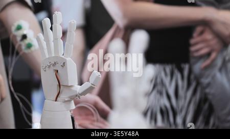A person controls an artificial robotic arm via wires on their hand. Stock Photo