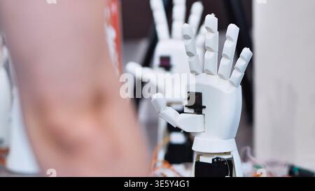 White robotic hand prototype with articulated fingers at a technology lab Stock Photo