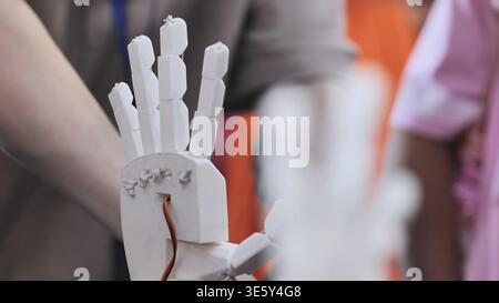 White 3D printed robotic hand prototype with wires and servo cable Stock Photo