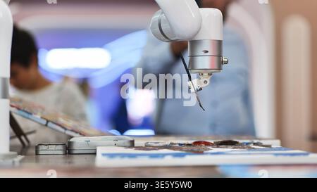 AI powered robotic arm holding a paintbrush and creating art on canvas Stock Photo