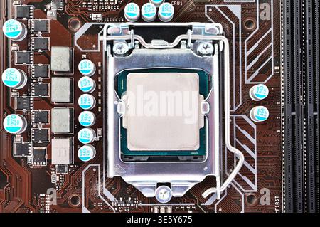 Close-up view of a computer motherboard with CPU socket and processor installed Stock Photo