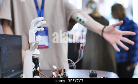 A person controls an artificial robotic arm via wires on their hand. Stock Photo