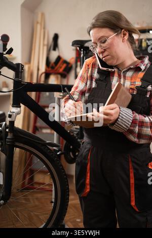 Female bike repairman repairing mountain bicycle with equipment for mechanic or technician in workshop. start-up. Bicycle repair, maintenance and Stock Photo
