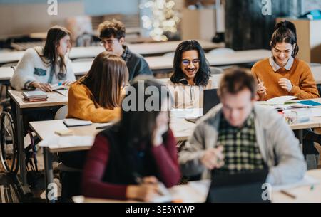 Students studying together in a modern university classroom collaborating on laptops and notebooks Stock Photo