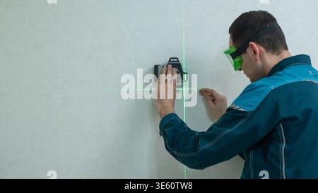 A man measures distance with a laser level.  Stock Photo