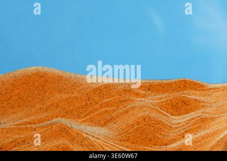 Smooth waves golden sand, creating desert relief under bright blue sky. Soothing interior composition Stock Photo