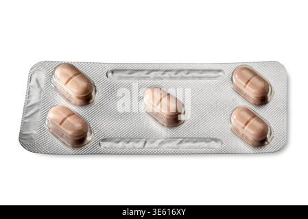Pinkish-brown tablets in a silver blister pack, view of tablets with a score line for cutting in half, isolated on white with clipping path included Stock Photo
