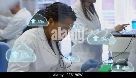 Pipetting tech in white lab coat, blue-gloved, moving liquid with pipette into tubes at lab bench Stock Photo