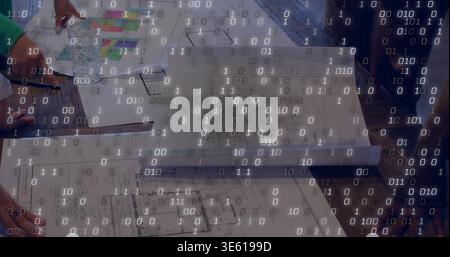 Pointing team hands arranging plans on wooden table, with swatch, binary overlay, sleeves Stock Photo