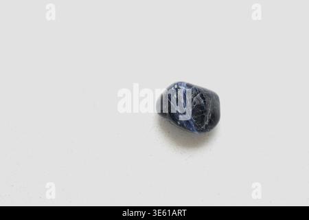 Top view of a natural sodalite stone displaying deep blue tones with white veining, highlighting its unique mineral texture. Ideal for concepts Stock Photo