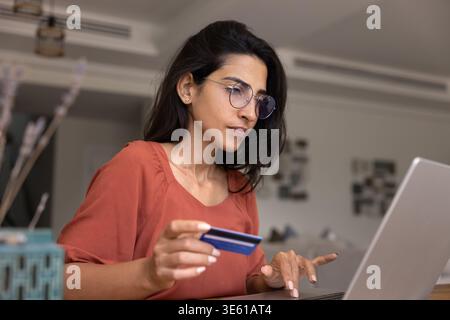 Woman paying bills using card and e-bank on laptop Stock Photo