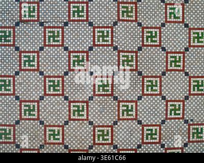Swastika symbol in ancient mosaic decoration. Old floor with mosaic ornament Swastika. Floor mosaics in Casa de la Cultura Benjamin Duarte in Cienfuegos, Cuba, Flat Lay, Background. Stock Photo