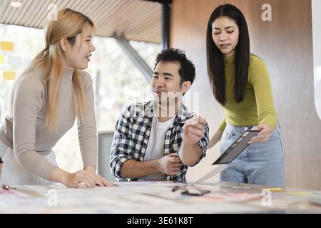 A diverse group of professionals engaging in a discussion and reviewing documents while collaborating on ideas at a modern office workspace Stock Photo