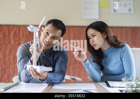 A focused discussion between two professionals about renewable energy solutions, emphasizing ESG business strategies in a modern office Stock Photo