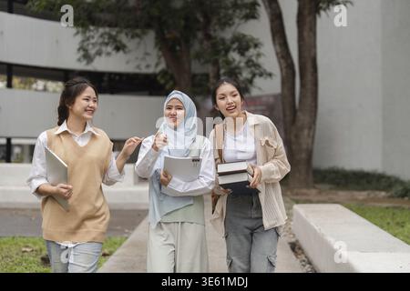 A group of diverse university students walking together and engaging in cheerful conversation while enjoying their time on campus Stock Photo