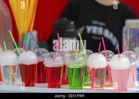 Colorful carbonated drinks in plastic cups with a straw close-up Stock Photo