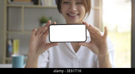 Mockup image of a beautiful woman hold a mobile phone with blank white screen Stock Photo