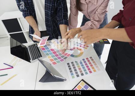 The team collaborates to decide on design elements, showcasing a professional approach to project planning using color schemes Stock Photo
