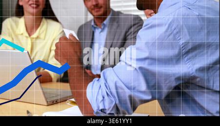 Leaning forward, man in blue shirt holding paper at meeting table with laptop, graph, copy space Stock Photo