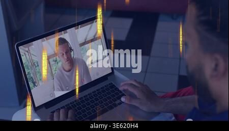 Typing local man operating laptop on lap at home, showing headset-wearing man in light T-shirt Stock Photo