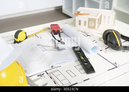 An array of engineering tools and construction plans displayed on a table, emphasizing preparation for a project Stock Photo