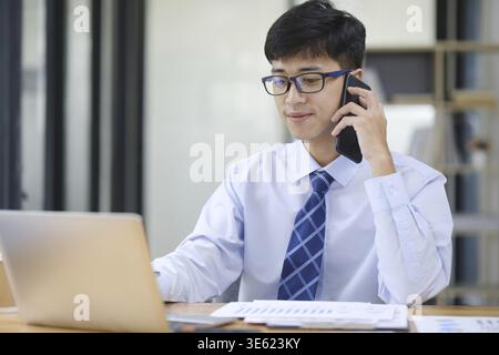 Confident businessman going over details of contract talking with partner on phone Stock Photo