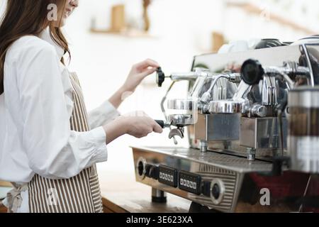 A barista operating an espresso machine to prepare coffee, demonstrating precision and expertise. The scene highlights the professionalism and attenti Stock Photo