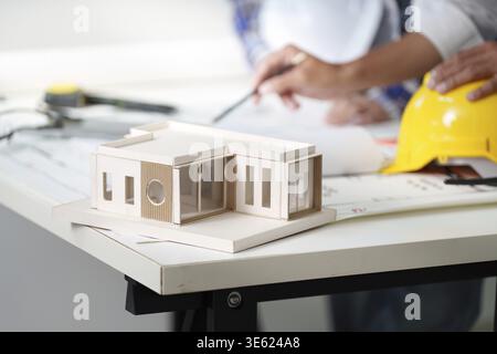 Engineers examining an architectural model on a table, highlighting teamwork and design in a collaborative workspace Stock Photo