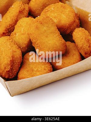 Food, Delicious chicken nuggets are piled high in a cardboard box, showcasing their crispy, golden exterior. Perfect for sharing at parties or enjoyin Stock Photo